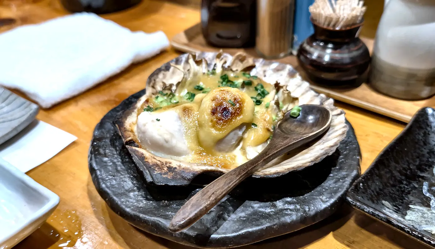 貝殻の上で味噌と卵をまとった帆立貝焼みそ