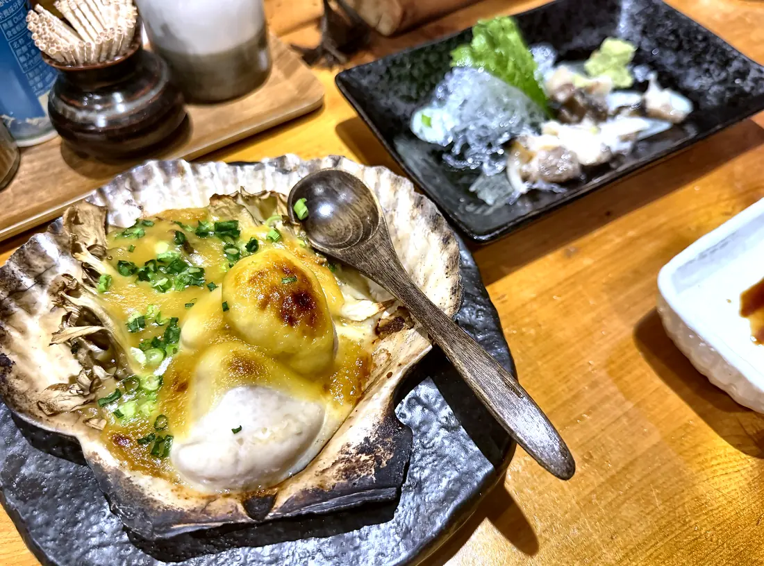 帆立貝焼みそや貝刺しなど数品が並ぶ卓上