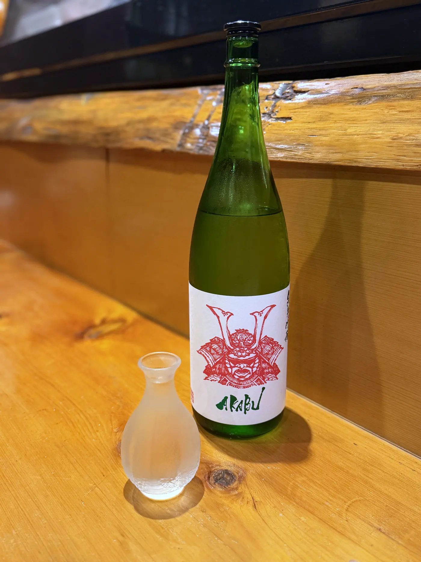 赤い兜のラベルの日本酒AKABUの一升瓶と徳利