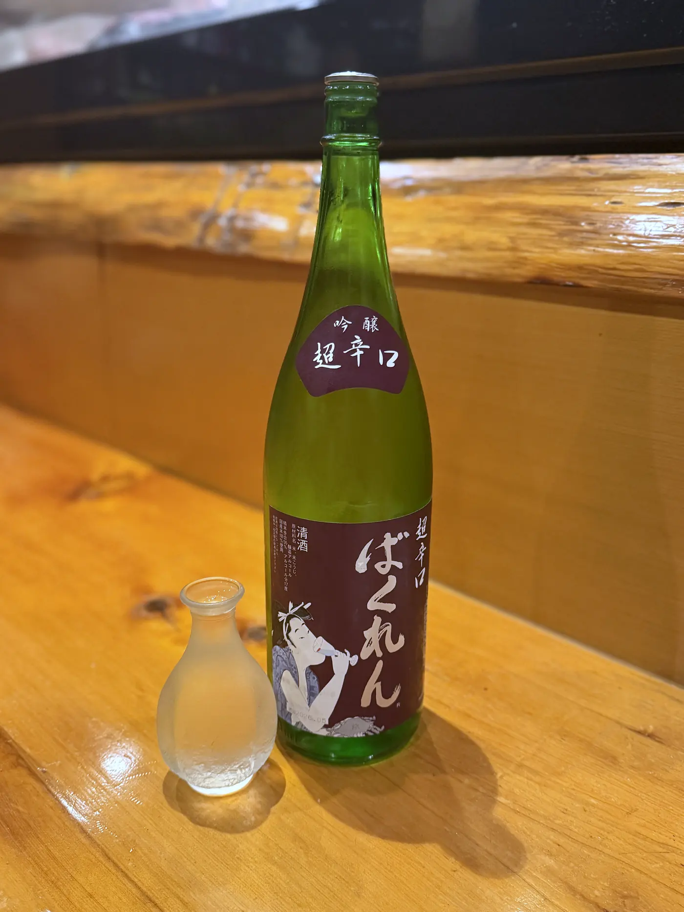 カウンターに置かれた超辛口吟醸「ばくれん」の一升瓶と徳利
